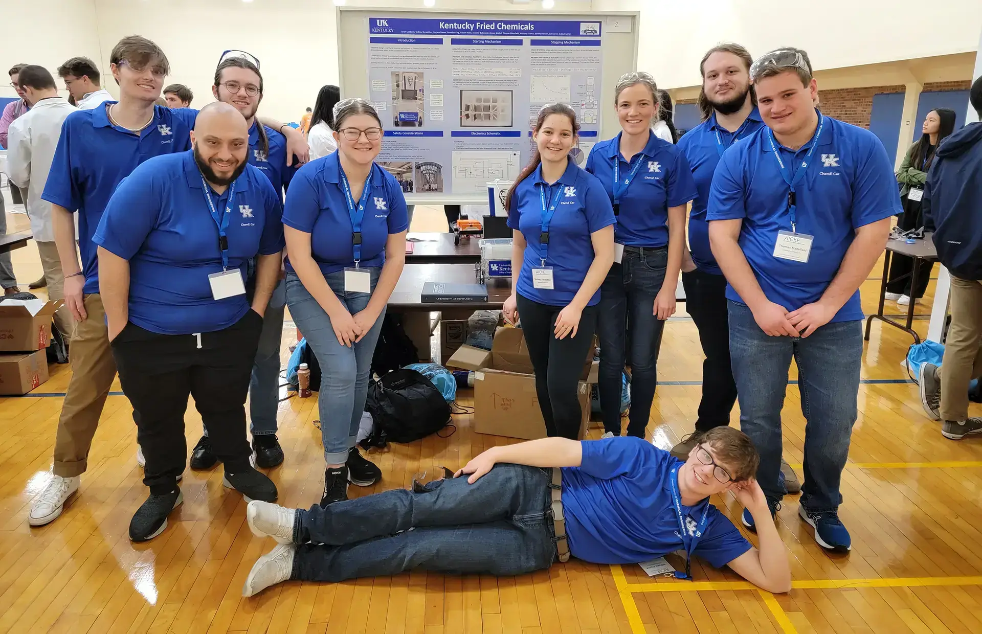 a University of Kentucky team at a showcase event wearing matching blue custom polos