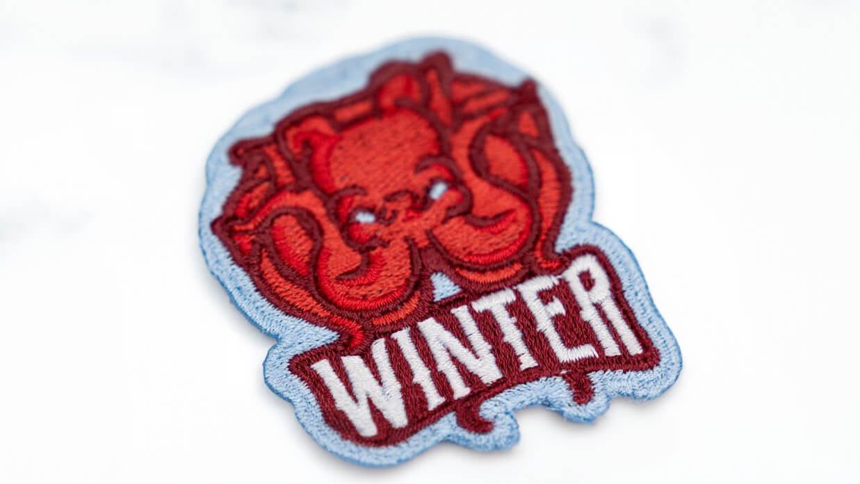 a custom embroidered patch with an octopus and the words winter