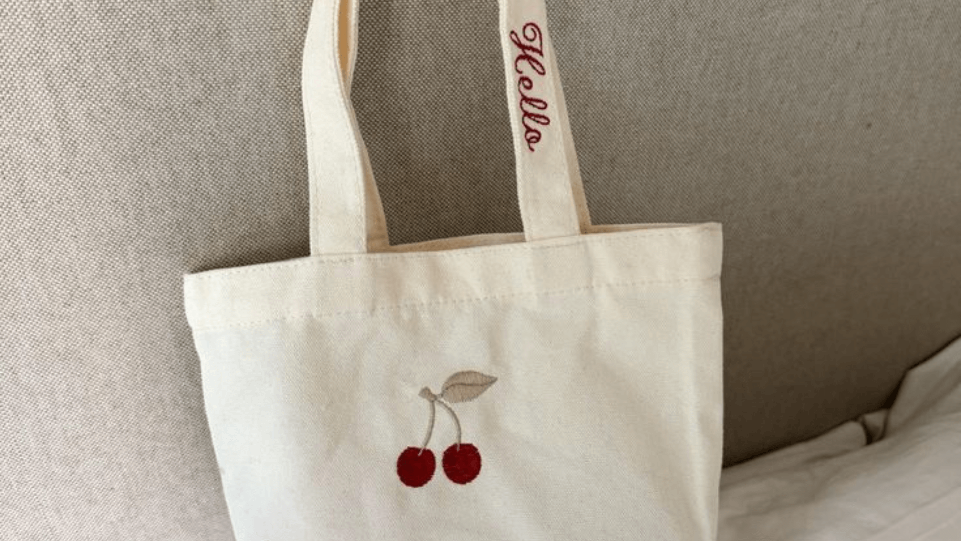 custom canvas tote bag embroidered with a cherry and the text "hello"