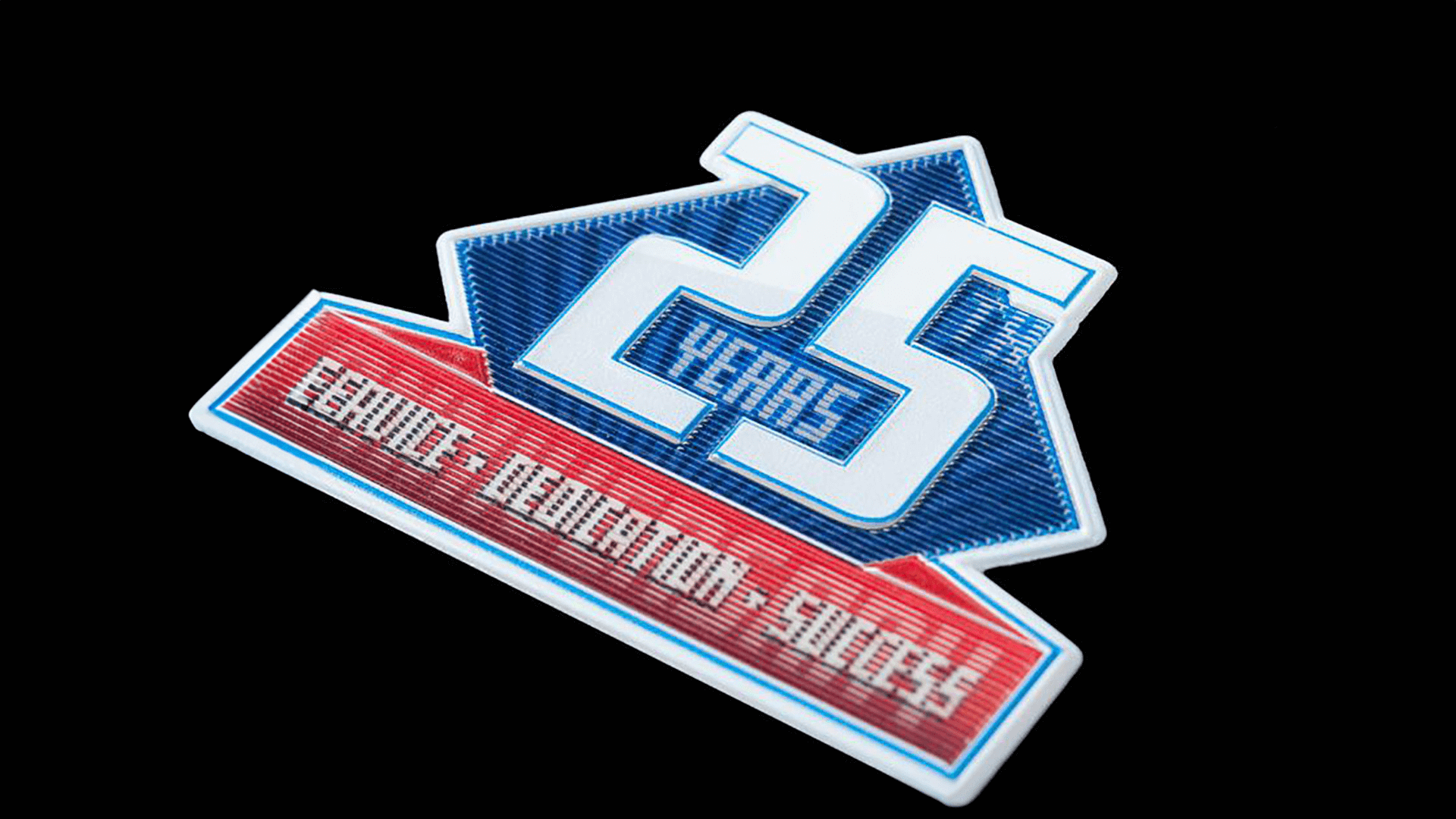 A large patch commemorating a "25 Years" anniversary in blue and red, with the words "Service • Dedication • Success" in metallic letters, displayed on a black background