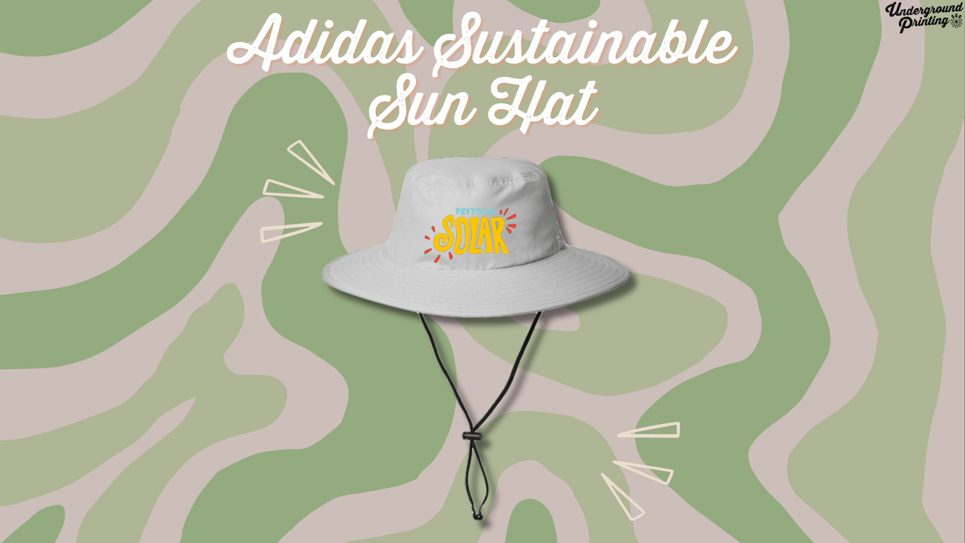 A light gray sun hat with a wide brim, featuring a custom "Festival Solar" logo in bright colors. The hat has an adjustable chin strap and is displayed against a green and beige camouflage-style background with accent lines around it.