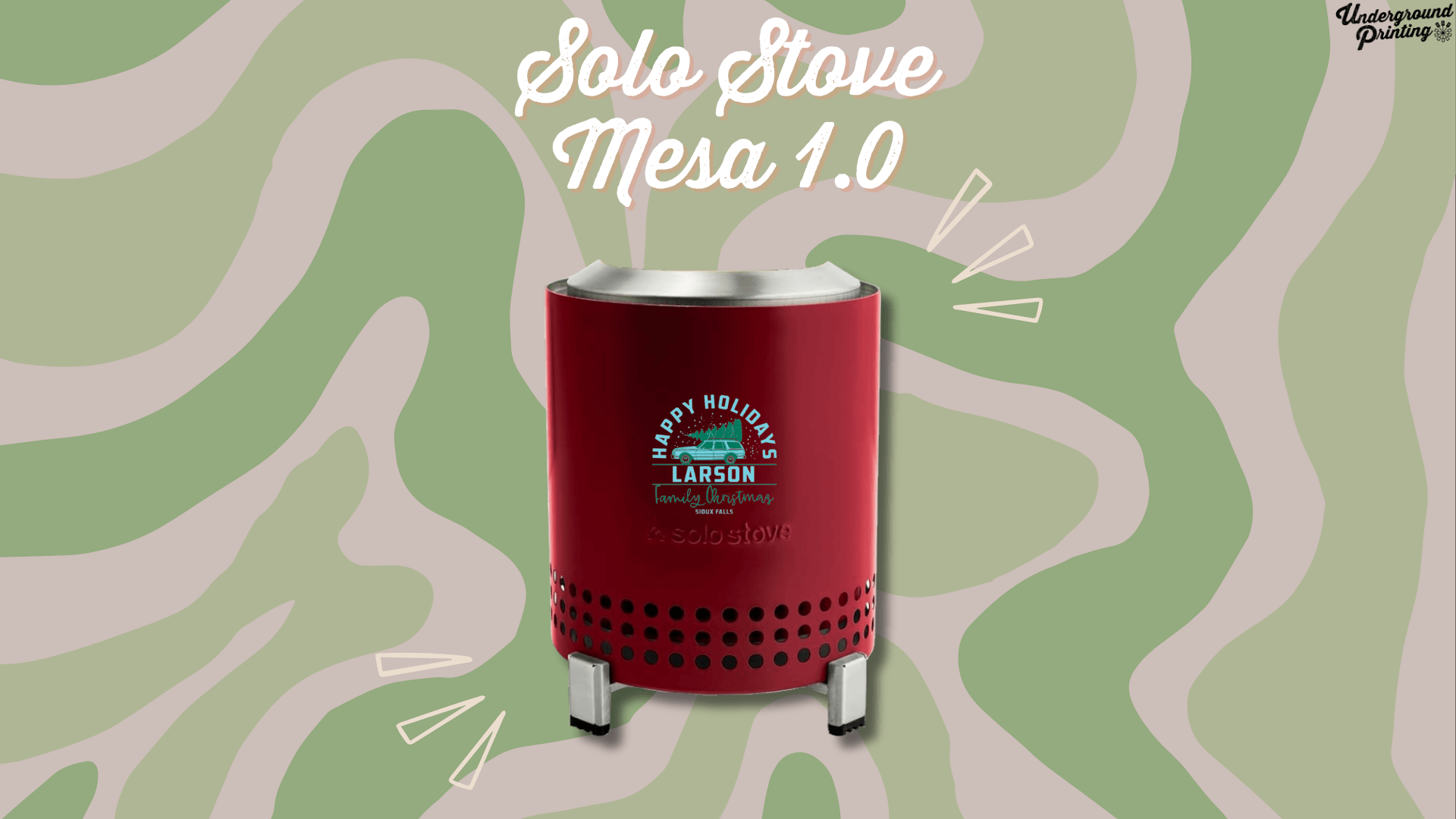 A compact red tabletop stove with a custom holiday logo for the Larson family. The stove is shown on a green and beige camouflage-style background with accent lines around it.