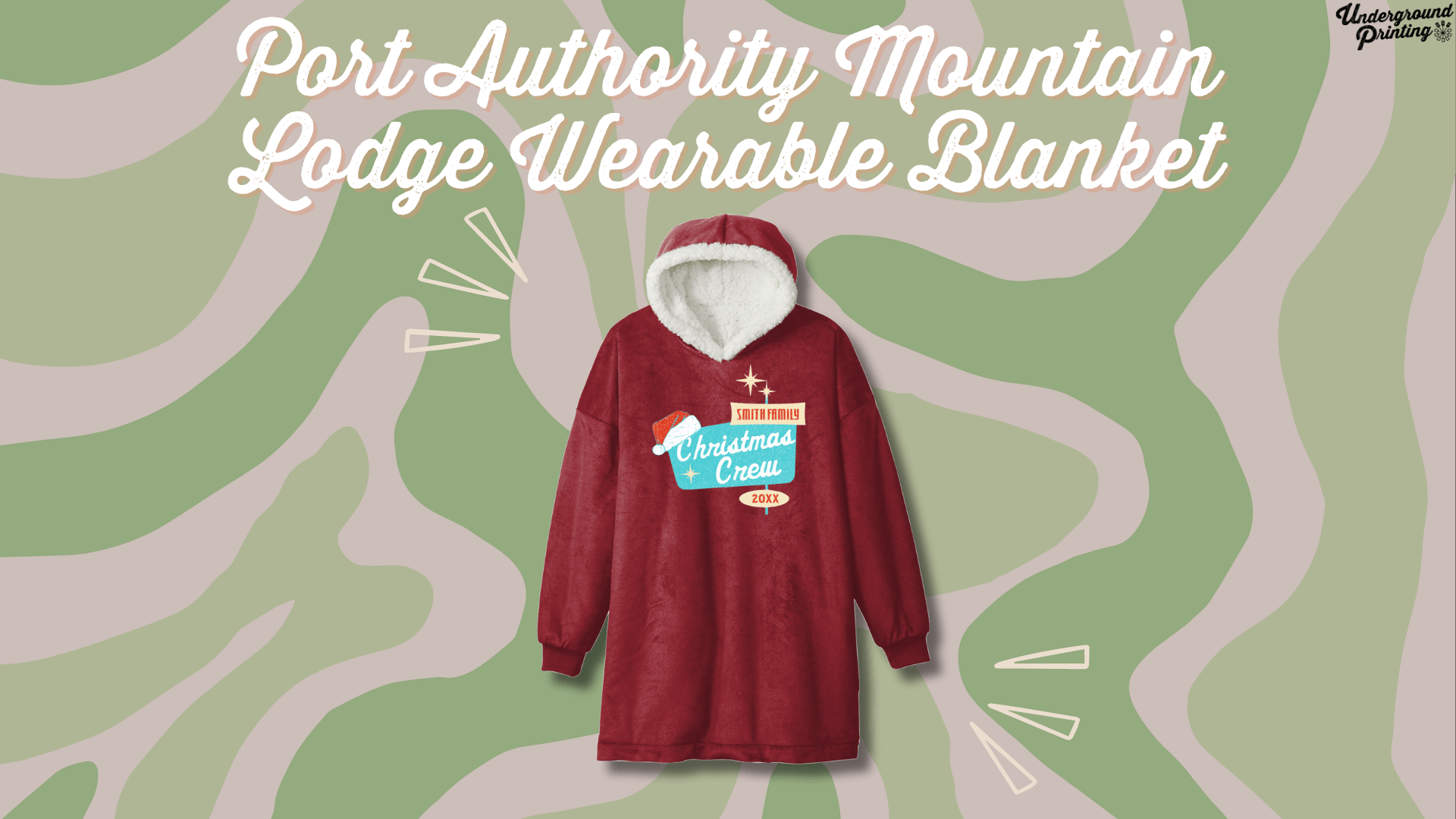 A cozy, oversized, red wearable blanket with a hood and sleeves, featuring a festive "Christmas Crew" design for the Smith family. Set against a green and beige camouflage-style background with accent lines highlighting the product.