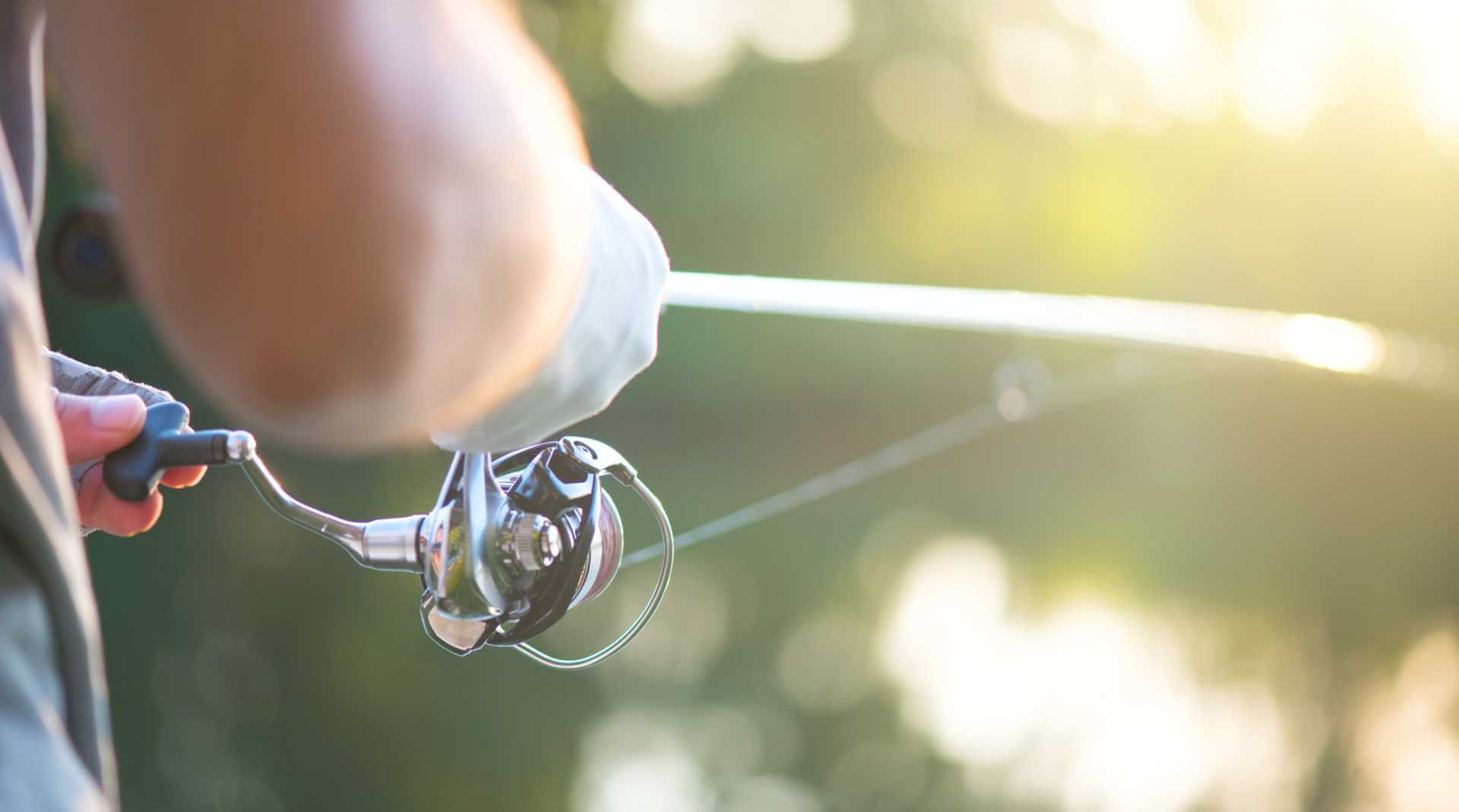 Angler adjusting fishing reel drag settings for better control
