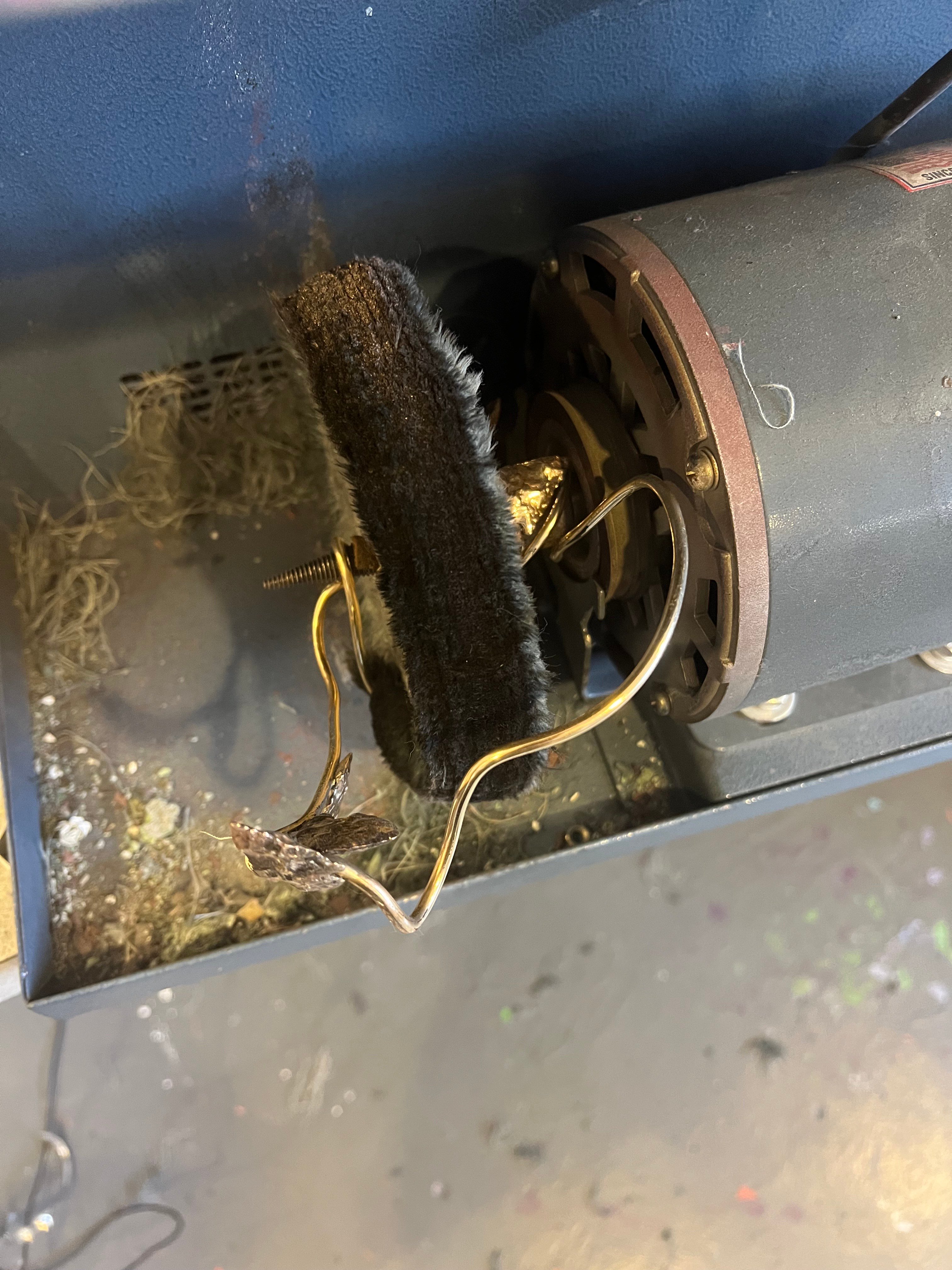 A polishing machine that has a piece of jewelry wrapped around it.