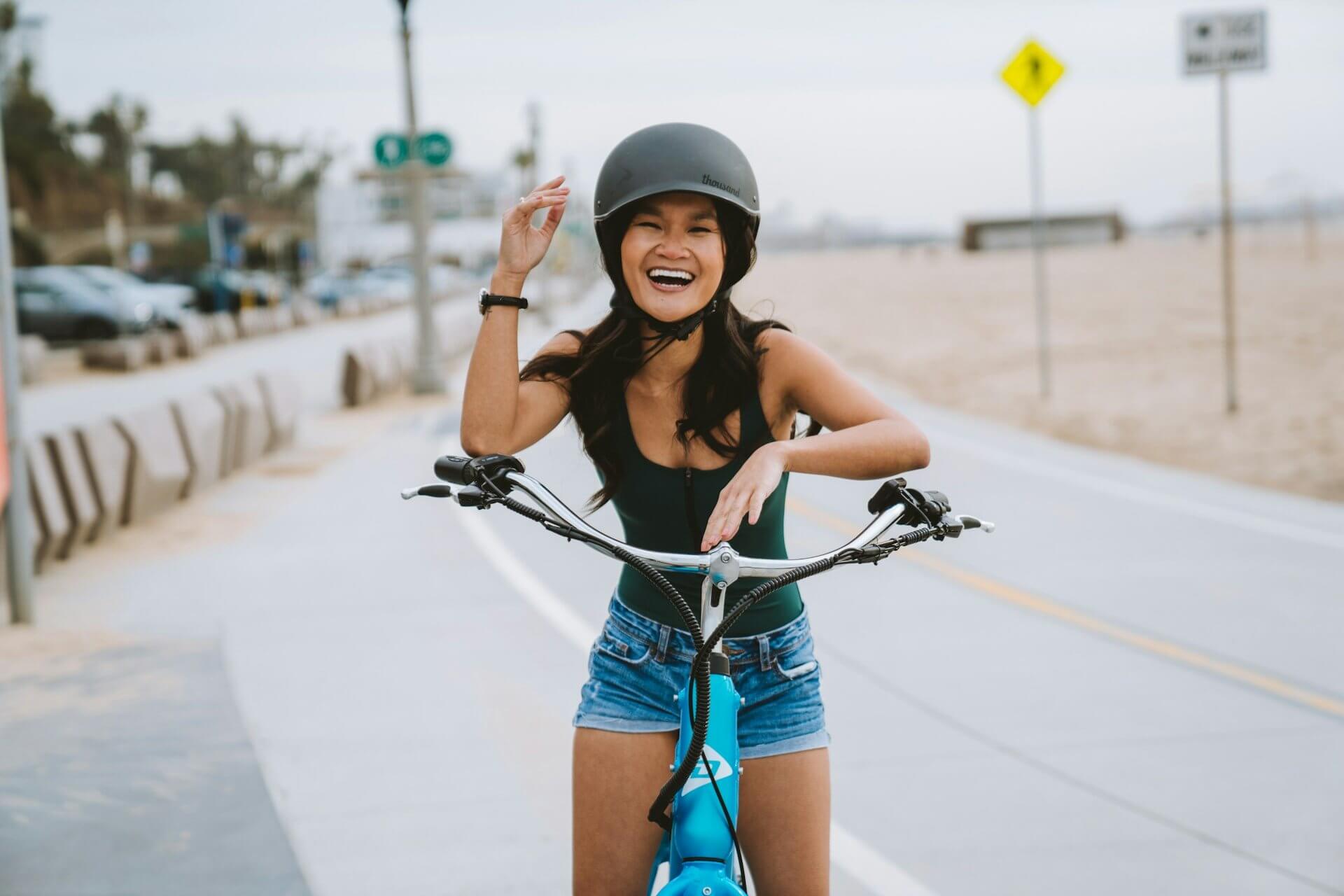 girl on a bicycle next to the beach