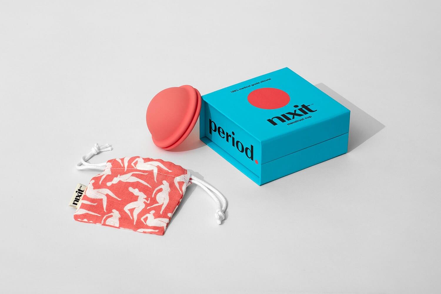 a pink menstrual disc with a carry bag next to a blue product box