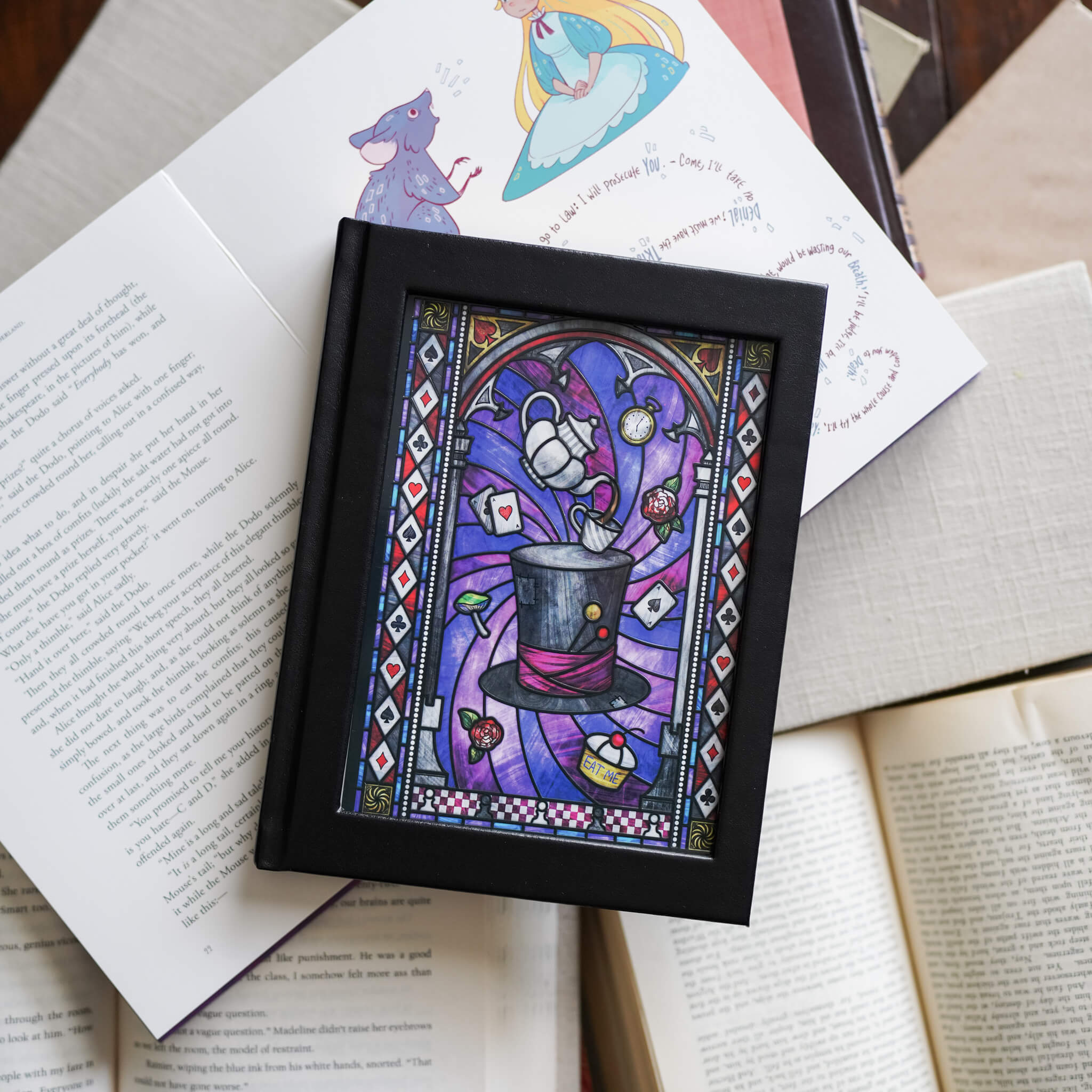 Black notebook with gold gilded pages and stunning stained glass design of Alice in Wonderland elements