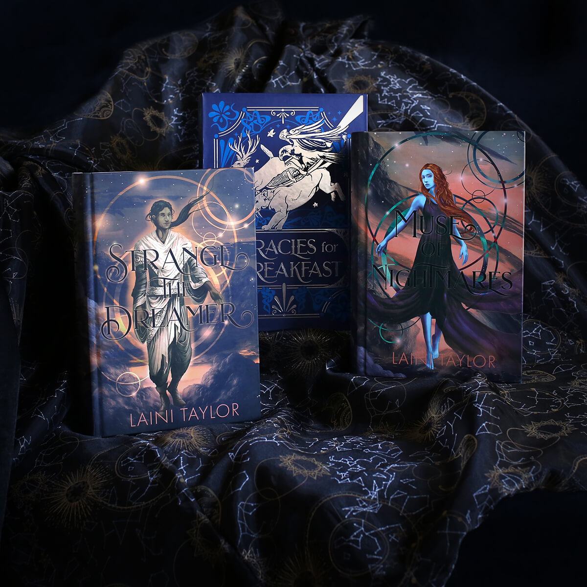 Strange the Dreamer and Muse of Nightmares by Laini Taylor with custom artwork placed inside a blue slipcase of silver foiled winged horses