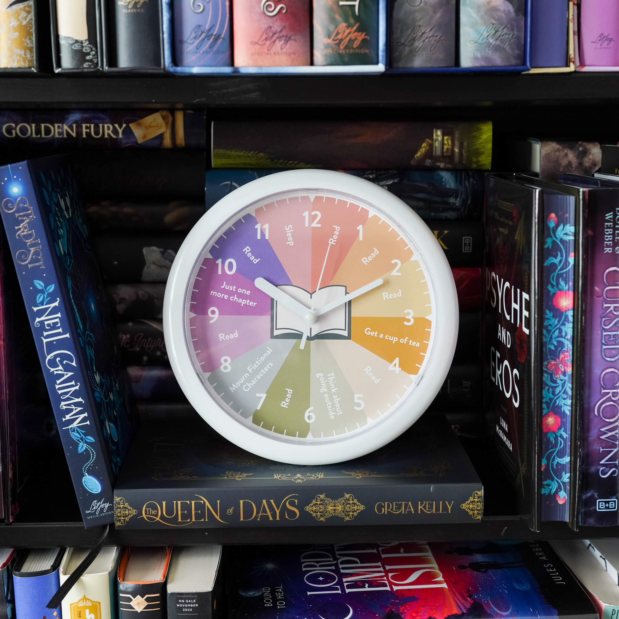 Cute plastic clock with rainbow face and each hour marked with reading phrases