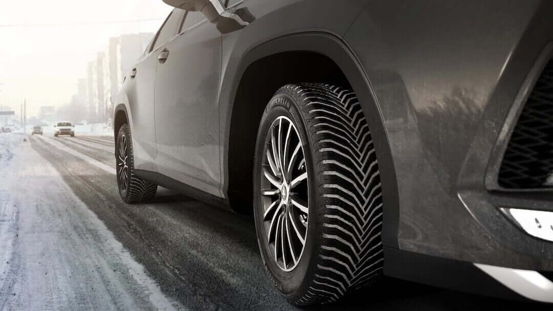 FRight side of an SUV wearing Michelin Crossclimate 2 tires on a semi-snowy road