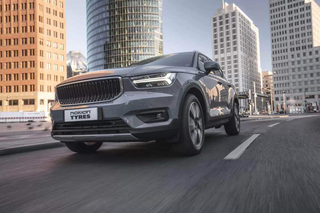 3/4 view of SUV with Nokian tires driving on city road