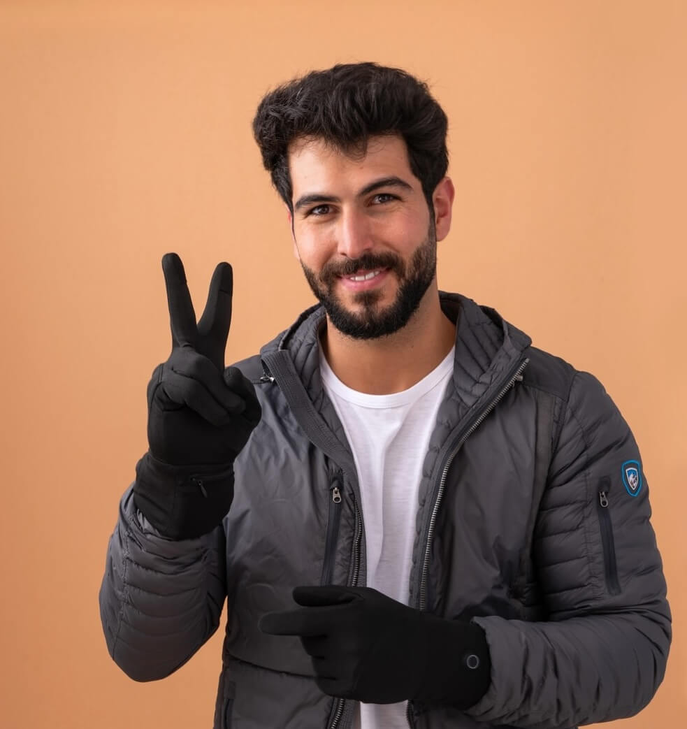 Cold Hand Man Showing Peace Symbol on orange background wearing Toasty Touch thin heated gloves