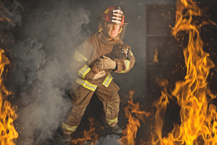 A firefighter holding a dog emerging from a burning building, Facing Sedona’s Risks: The Necessity of Pet Disaster Preparedness