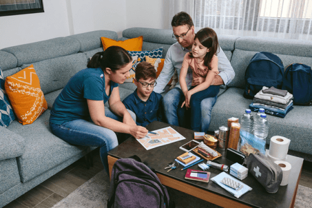 A family sitting on a couch looking at an evacuation plan