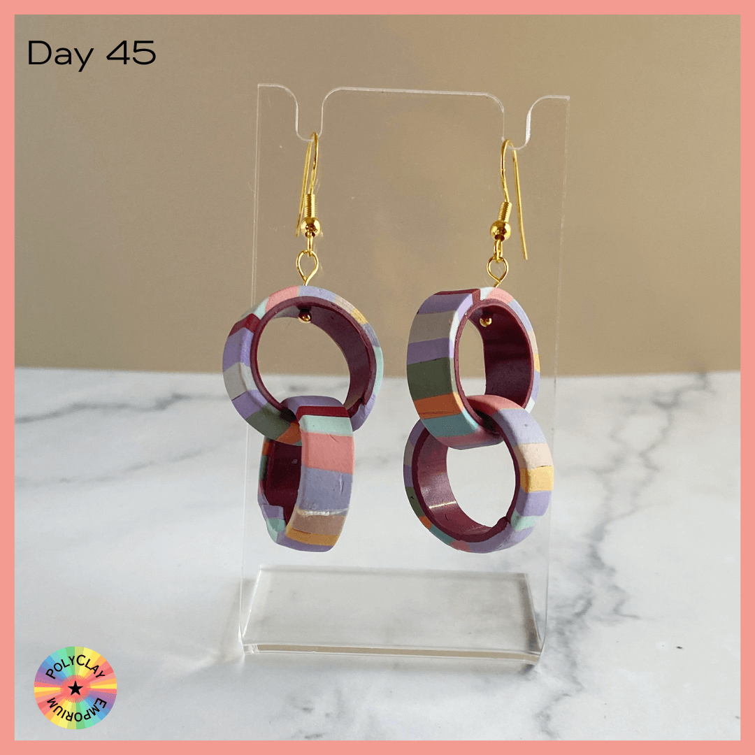 Double Hoop polymer clay earrings, striped outside, dark crimson inside.