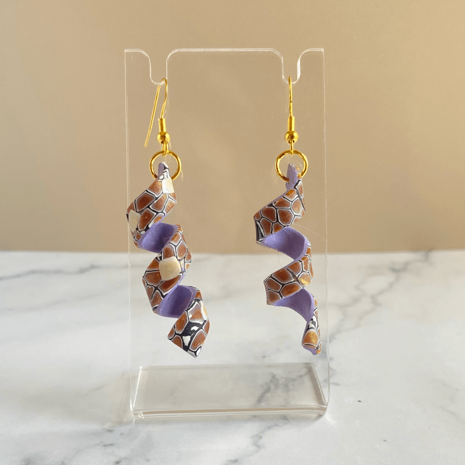 A beautiful pair of spiral polymer clay earrings with lavender colored lining