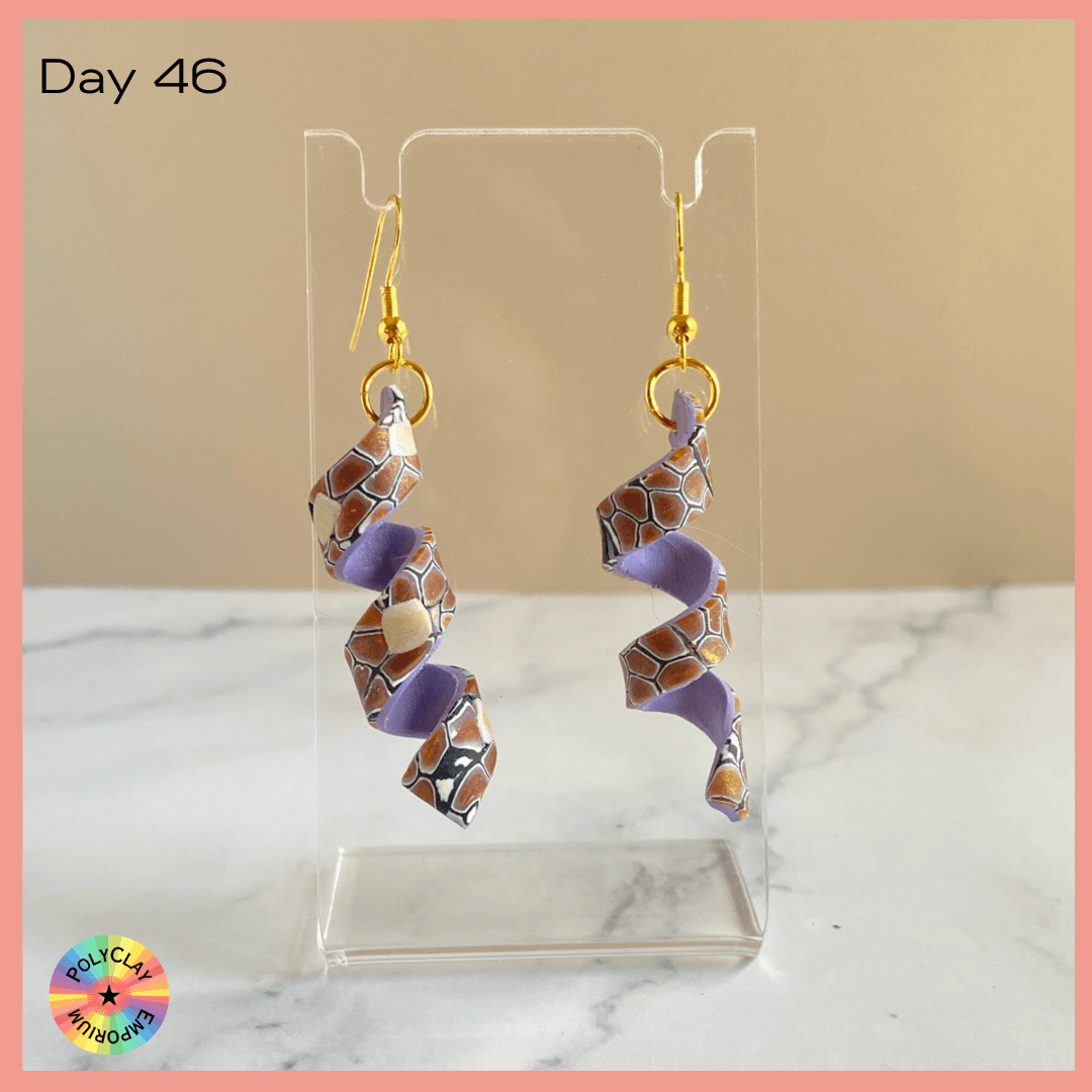 Polymer clay spiral earrings, brown toned slab on the outside, bright lavender on the inside