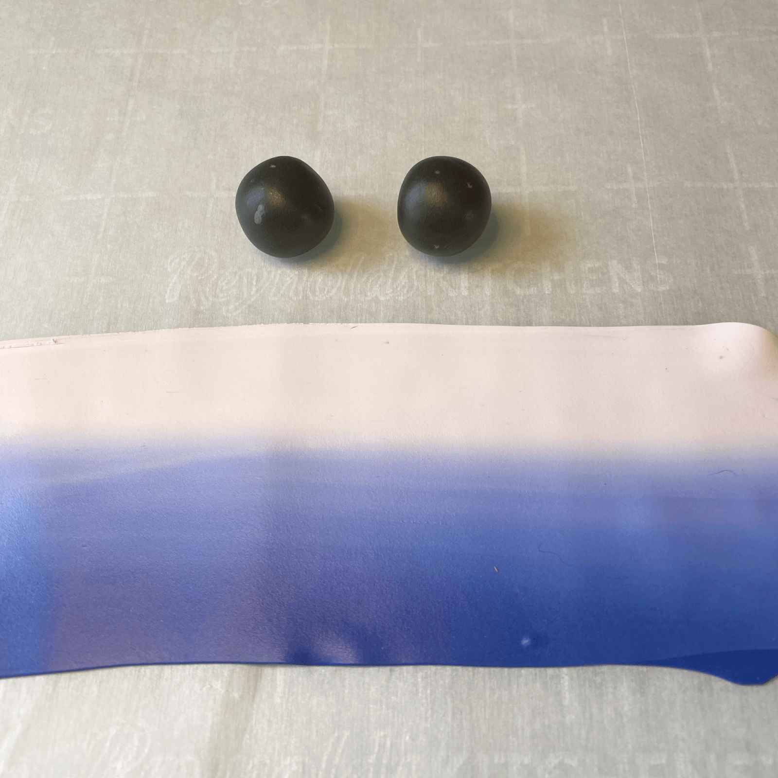The skinner blend laid out flat and two base beads made of scrap clay