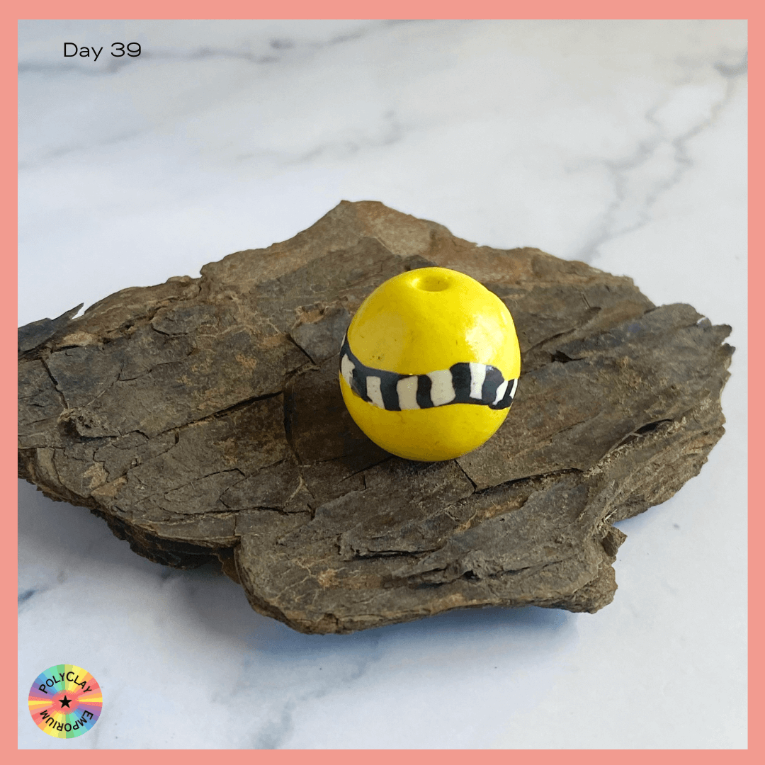 Polymer Clay A bold yellow bead with a black and white stripes equator