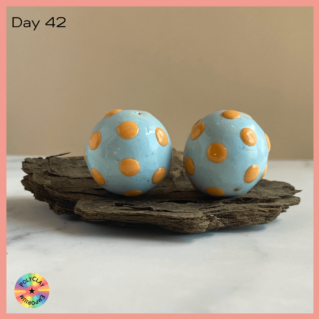 Pale aqua polymer clay beads with orange dots