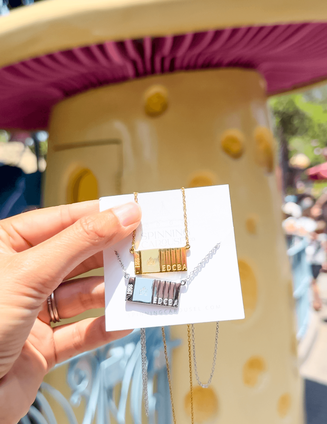 Ticket to Magic Necklaces in Silver and Gold in front of abandoned Ticket Booth in Disneyland Park