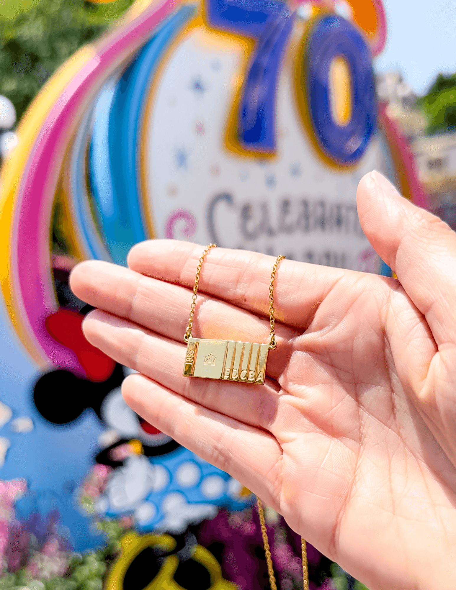 Ticket to Magic Necklace in Front of Disneyland's 70th Anniversary Decorations