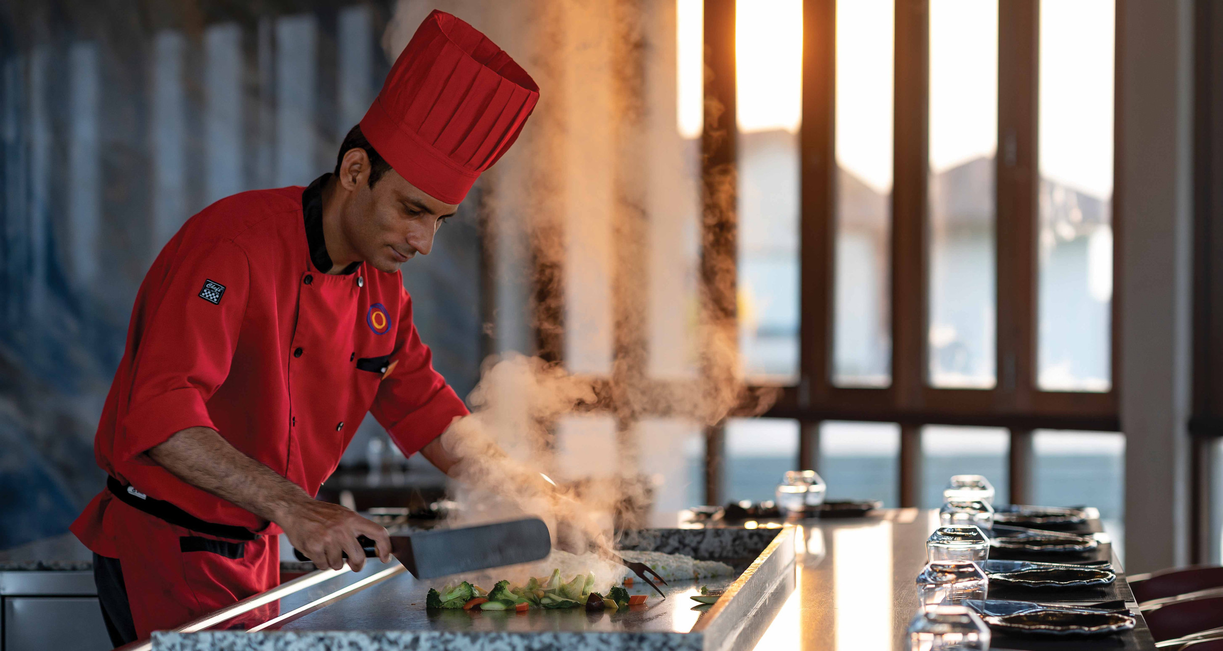 A chef preparing vegetables at a teppanyaki grill at Atmosphere Kanifushi.