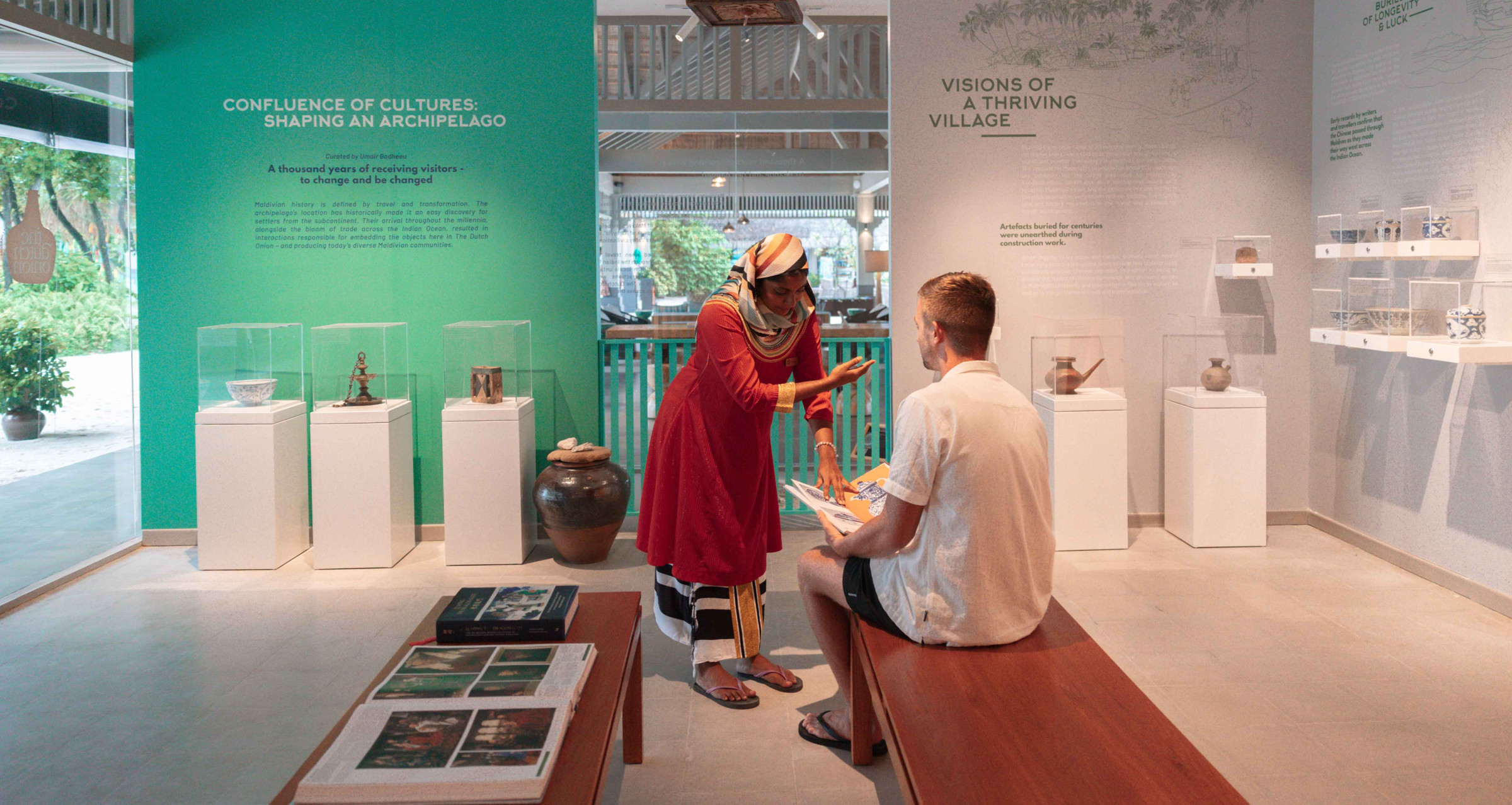 A Maldivian lady teaching a white male about artefacts at the Dutch Onion Museum at Cora Cora Maldives.