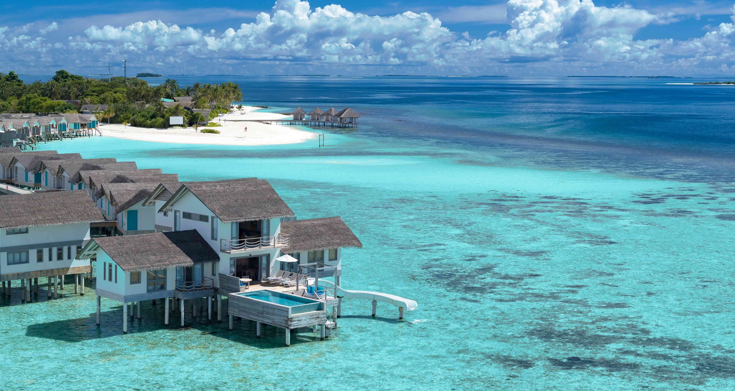 An image of the Two Bedroom Lagoon Villa with Pool and Slide at Cora Cora Maldives - the last villa at the end of the jetty, with some of the island in view in the background.