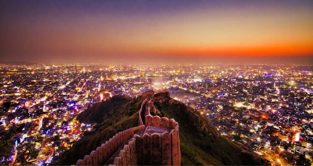 Diwali in Jaipur, over looking the city as the sun is setting with lots of colourful street lights down bellow