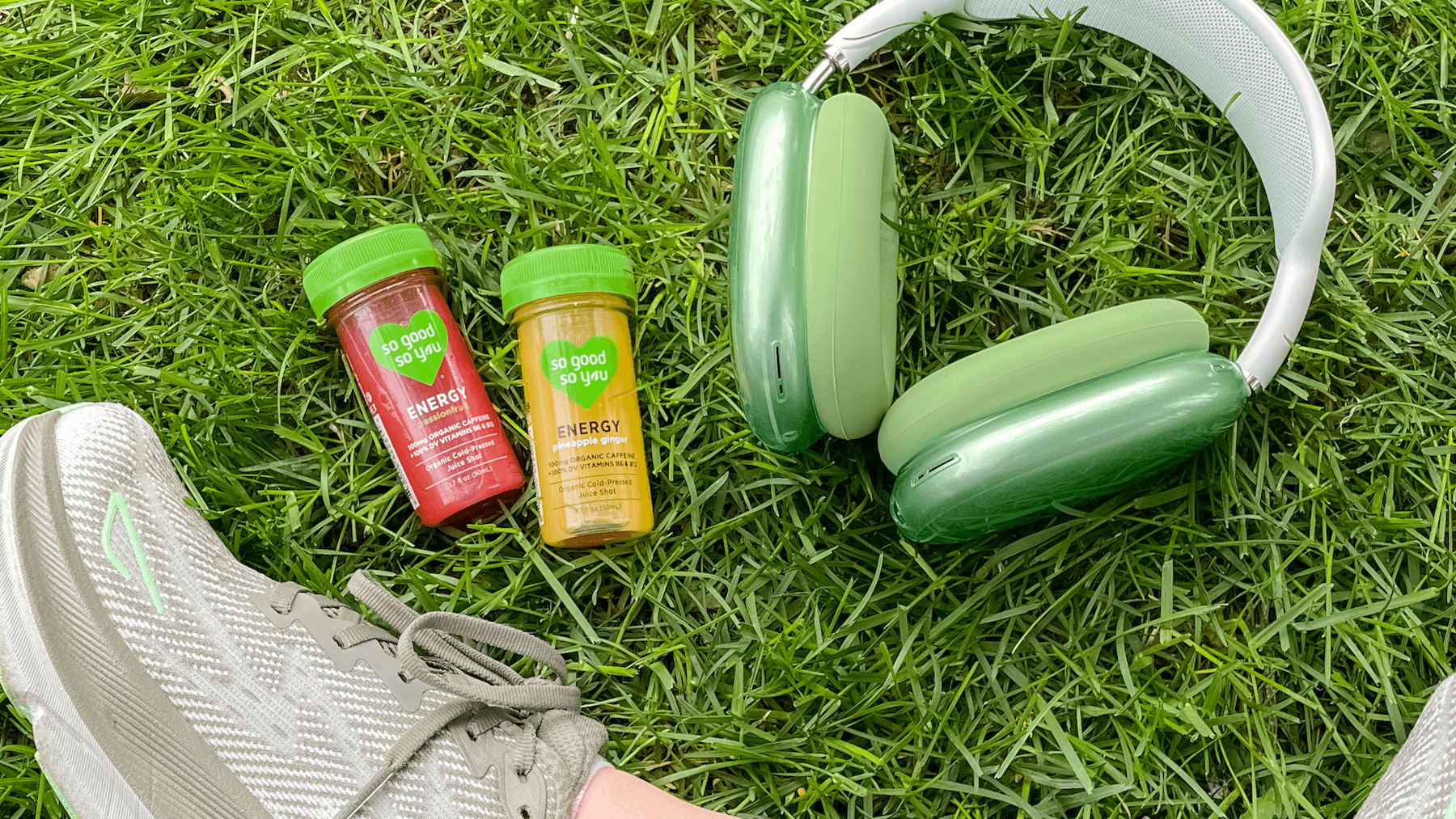 Energy Shots next to headphones on grass.