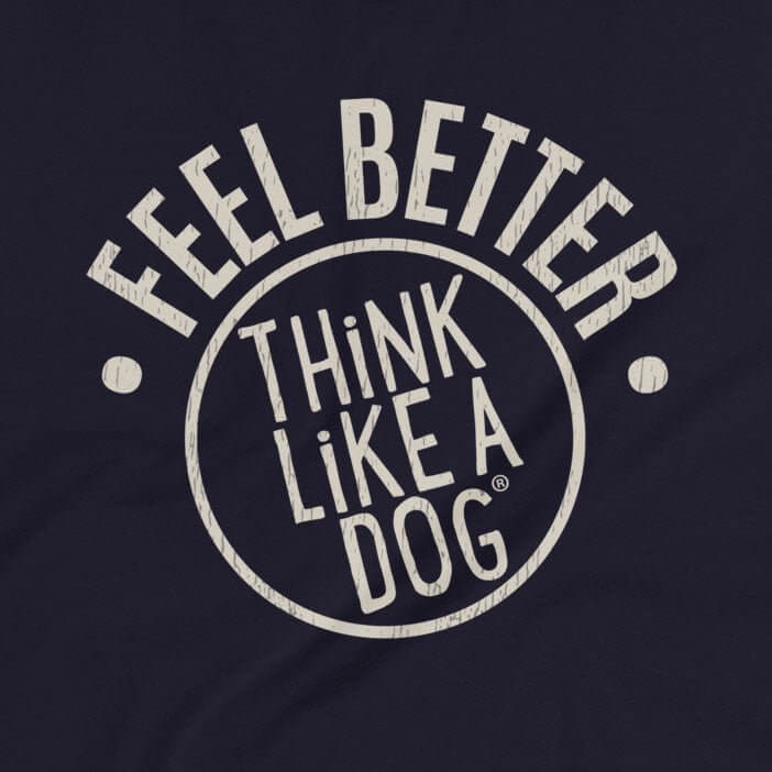 Close-up of a t-shirt design featuring the phrase 'FEEL BETTER' in bold, distressed text above a circular THiNK LiKE A DOG® logo. The light tan text stands out against the dark background, creating a clean and motivational design.