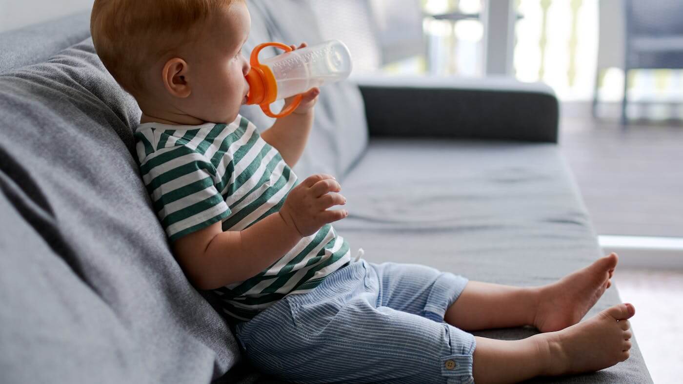 Young boy drinking clear tap water. There are rising concerns about potential health risks from fluoridated drinking water.