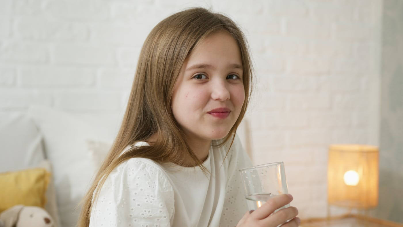 Girl drinking tap water amid concerns about health risks from fluoridation after recent court ruling