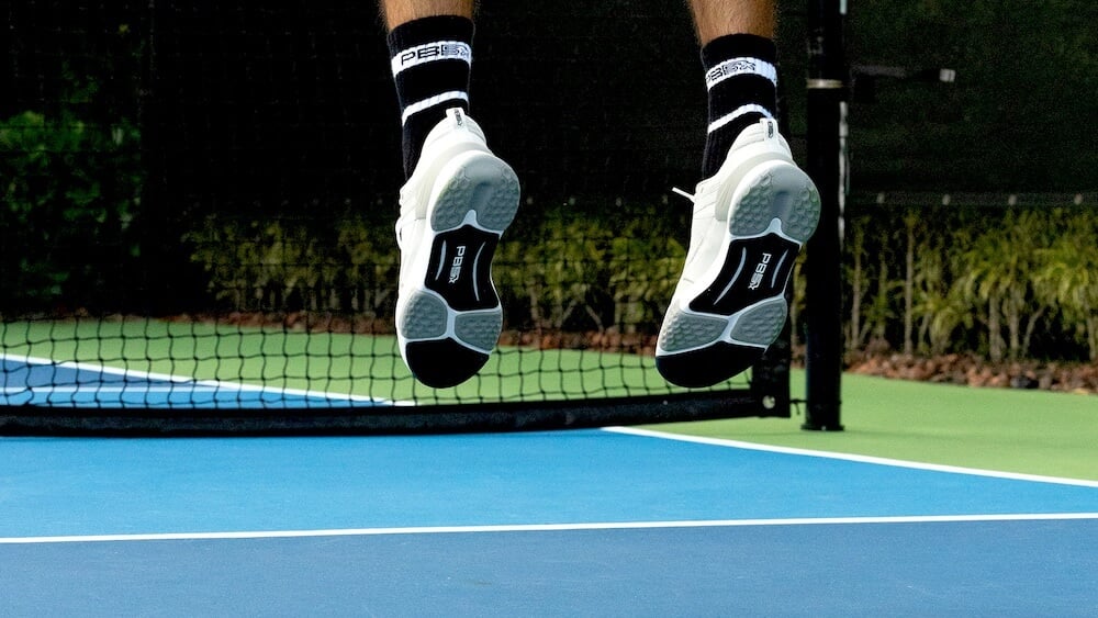 Close up of feet jumping on a pickleball court