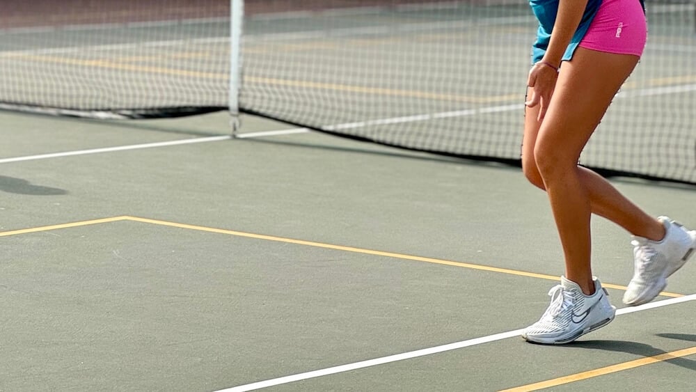 Close up of someone running on a pickleball court