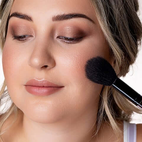 Blush being applied to model's cheek.