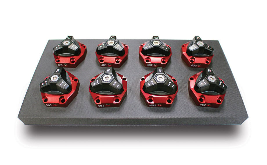 A QA1 MOD Series QuickTune valve pack being swapped out, showcasing the modular adjustability for rapid tuning changes.