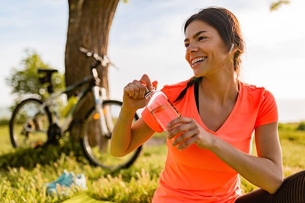 Live Healthier with Olive Oil! This healthy woman holds her water bottle and is ready to take a bike ride.