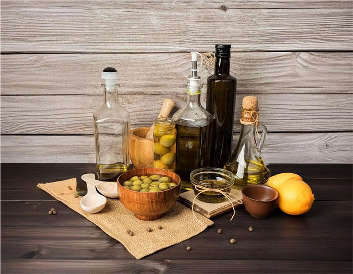 Olive varietals shown with  olives and assorted bottles of extra virgin olive oil