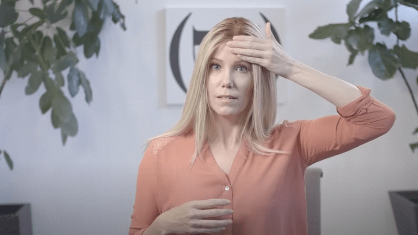 Image of a woman carefully placing a front lace wig, measuring four fingers from her eyebrows for a natural and realistic look.