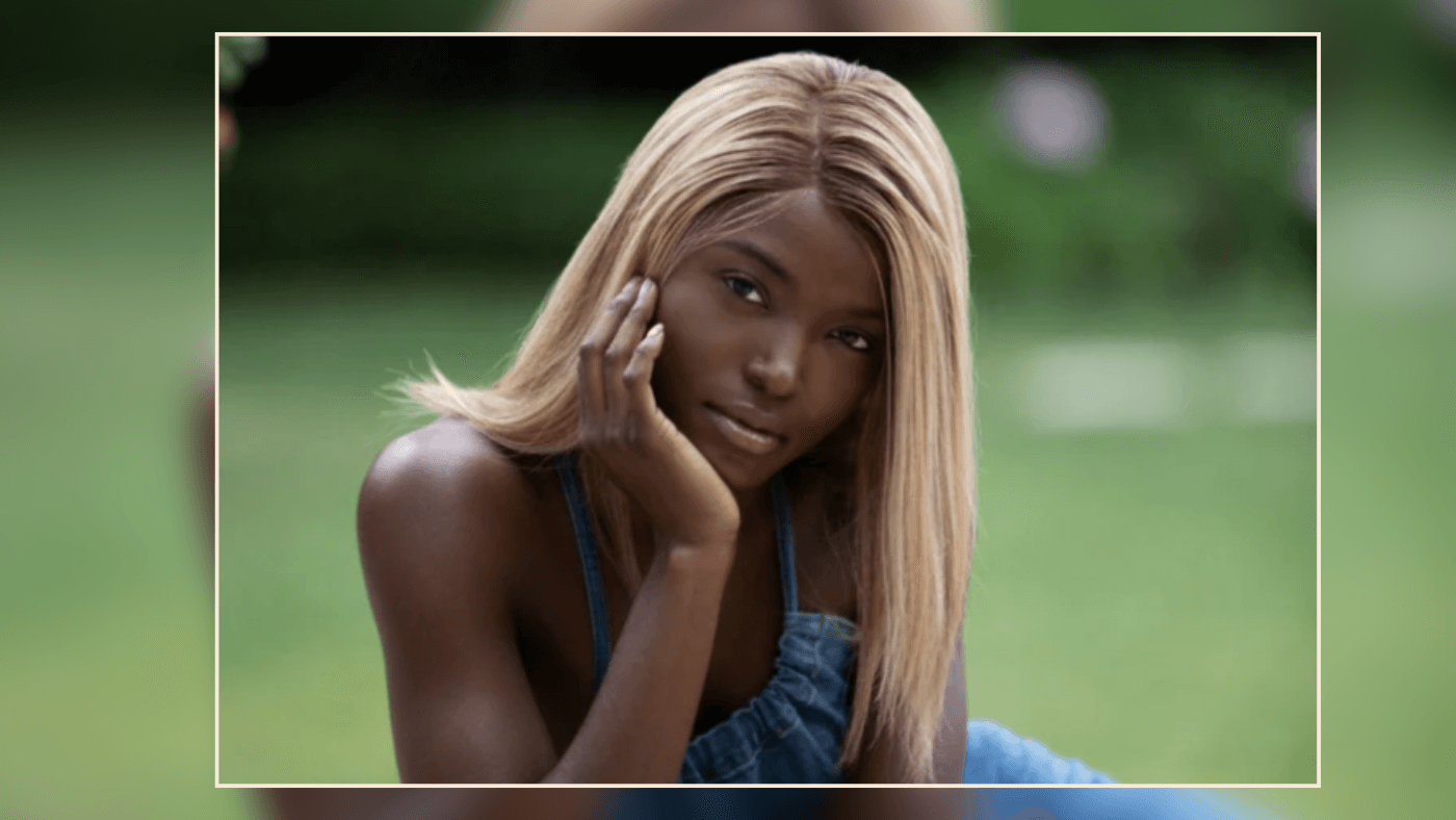 Outdoor portrait of a woman with a medium-density wig, radiating confidence in a sunny environment.
