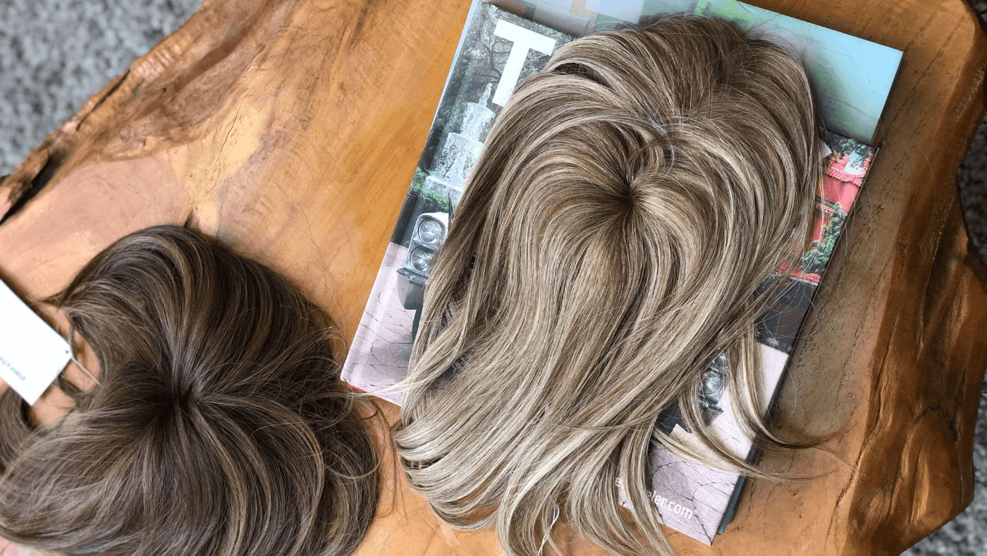 Two hair toppers arranged on a table, demonstrating their appearance and purpose for enhancing hair volume and coverage.