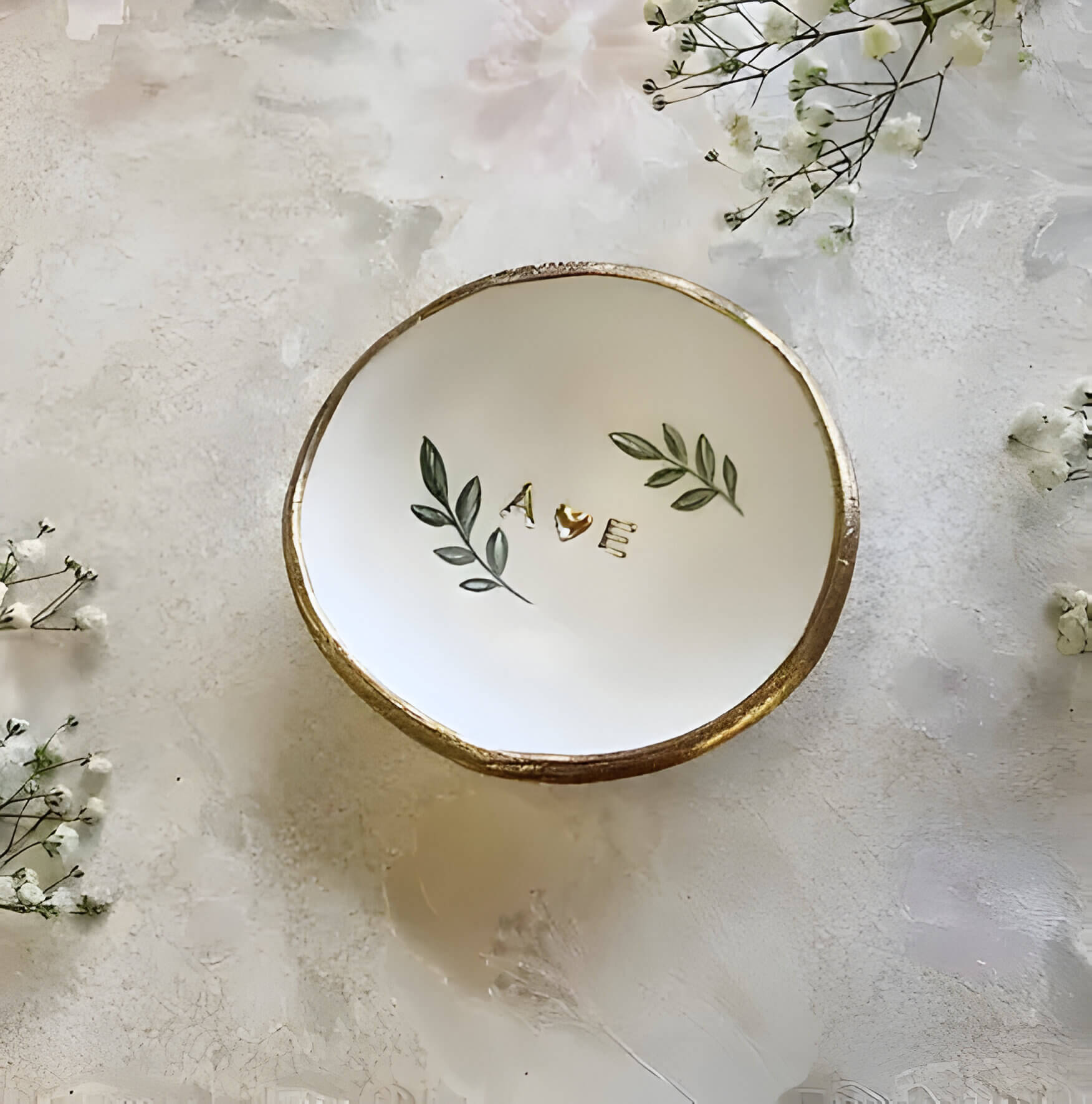 a small dish with gold lettering
