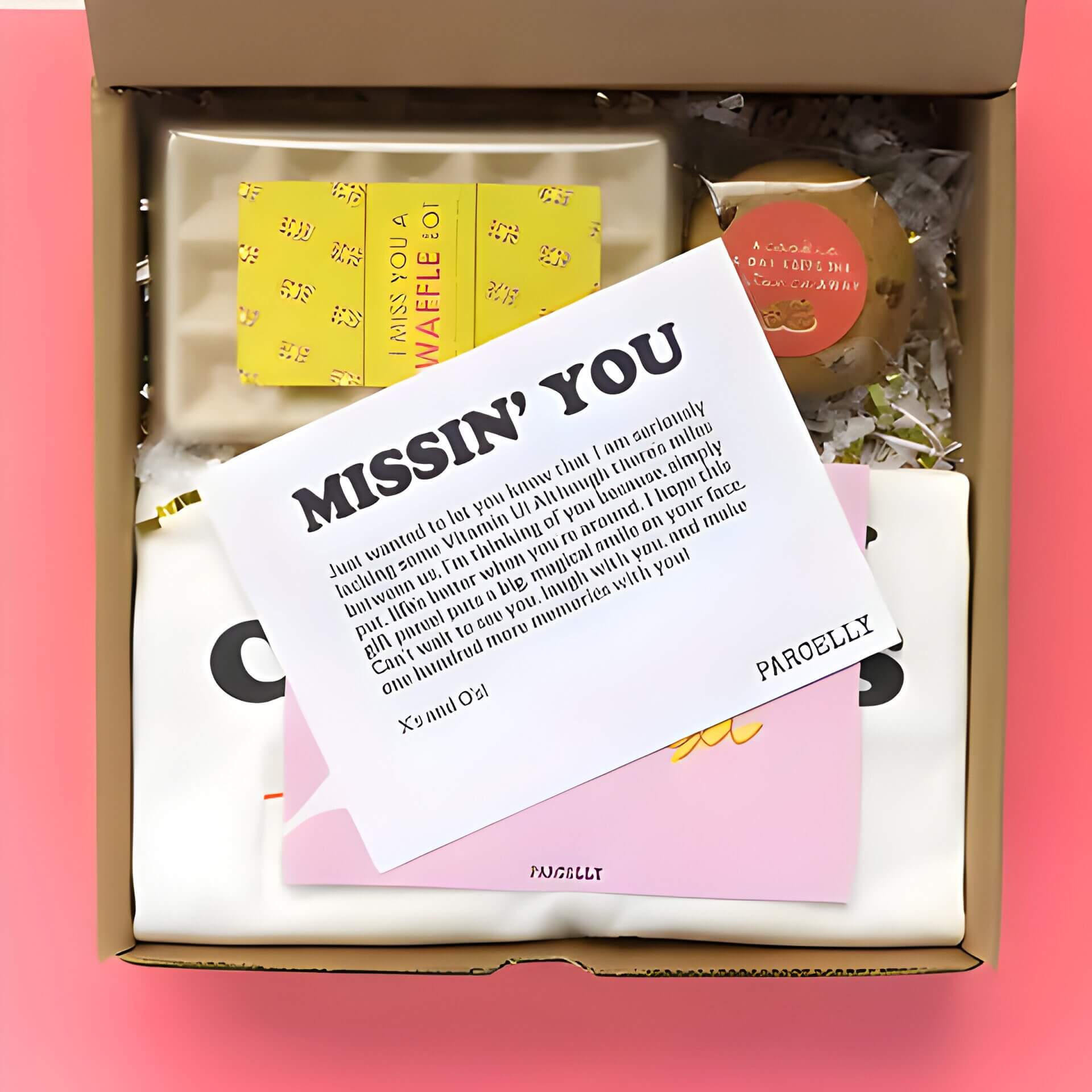 a box containing colourful gifts and a white card with "missin You"