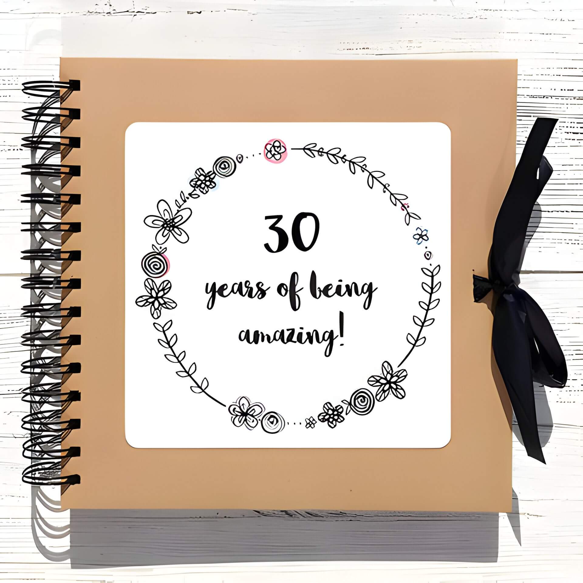 a brown scrapbook with 30 years of being amazing on the front