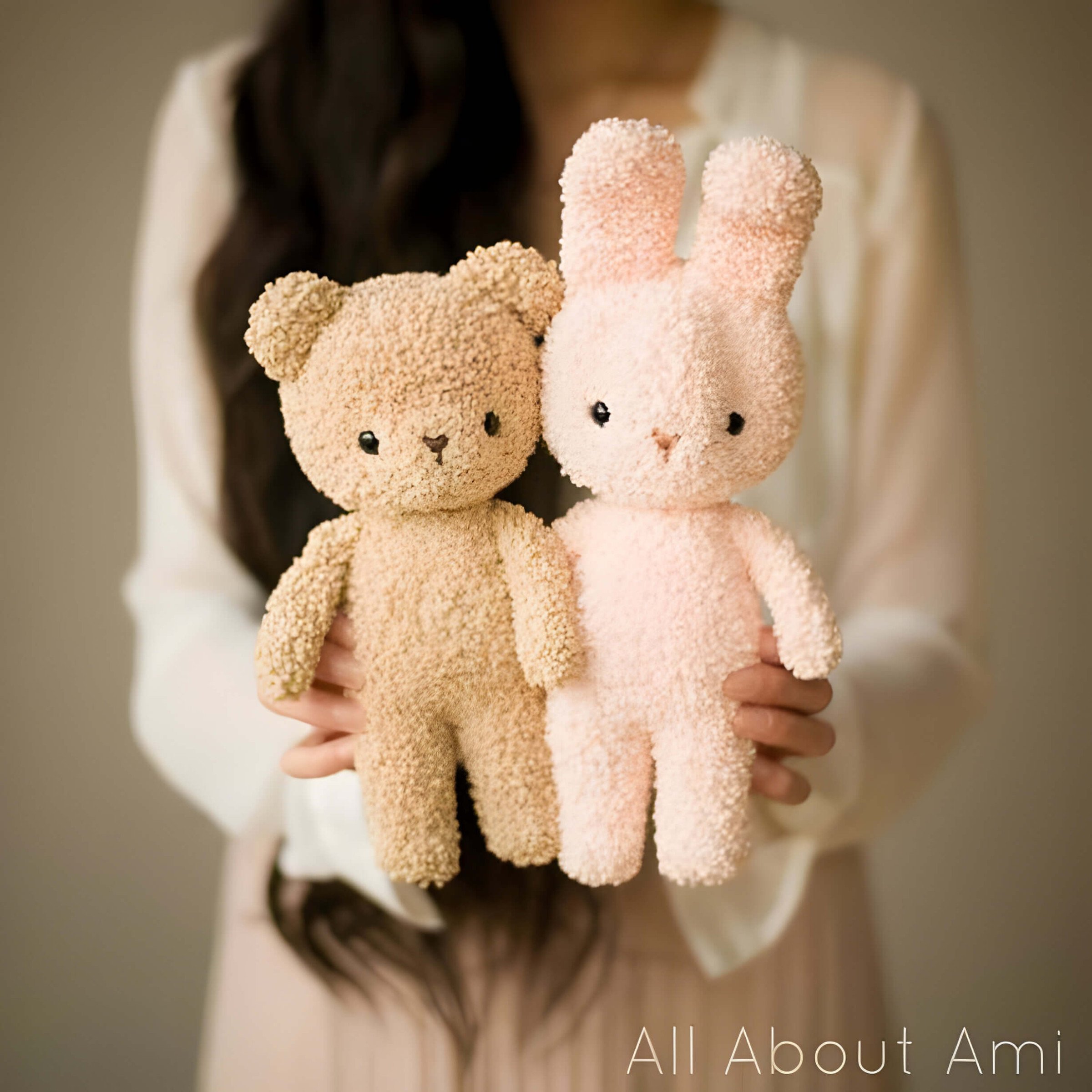a brown bear and a pink rabbit cuddly toy being help up by a child