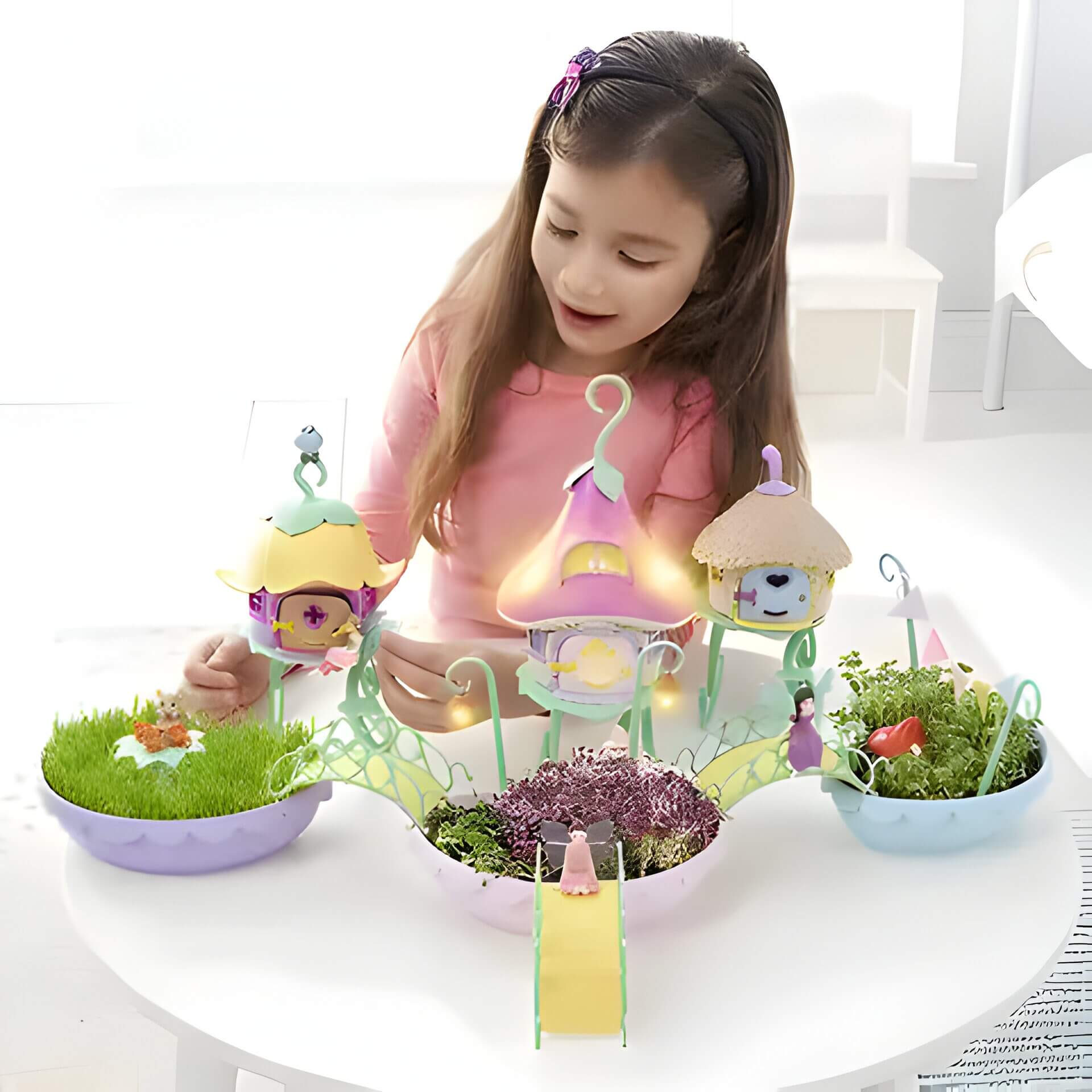 a little girl playing with a fairy garden toy