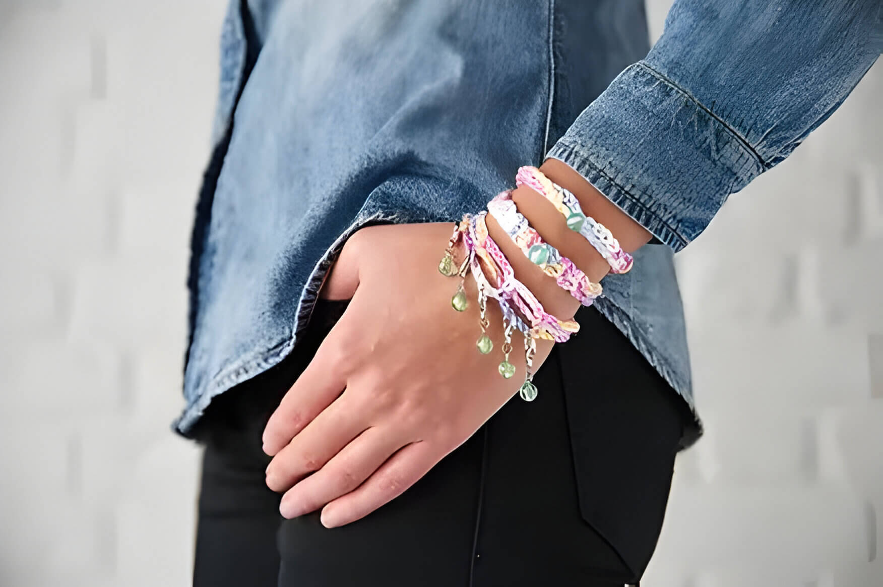 a person wearing 3 crochet friendship bracelets